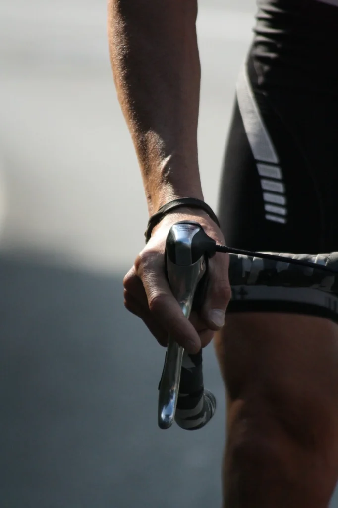 A close-up of a cyclist's hand gripping the handlebar, a symbol of the control and precision honed through a dedicated training plan platform.