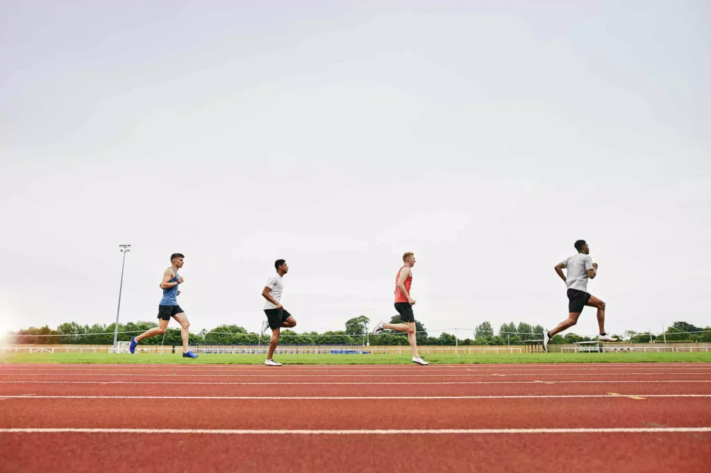 Group of runners training on a track, focusing on Intensity Factor to optimize their workouts.